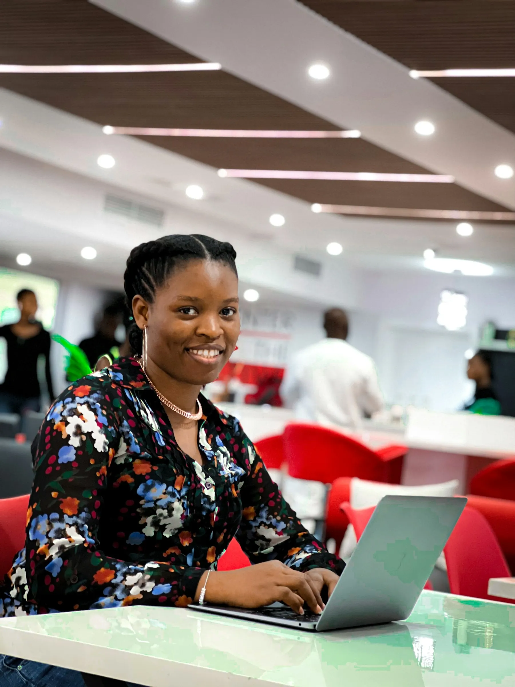 A young woman at a laptop, smiling