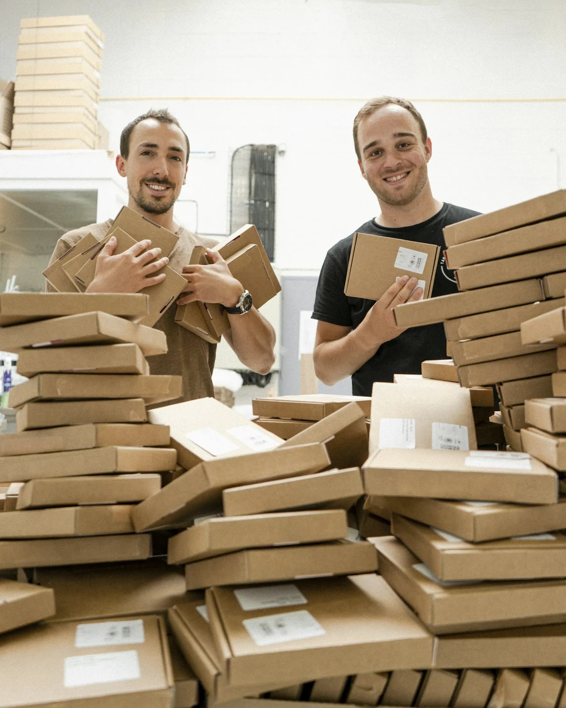 Two men with stacks of packed boxes